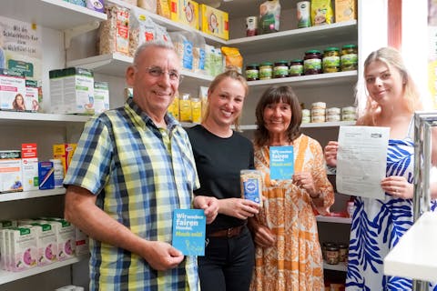 Das Ehepaar Höckh mit Bürgermeisterin Julia Wieland und Sarah Baureithel vor einem Regal mit Fairtrade-Produkten