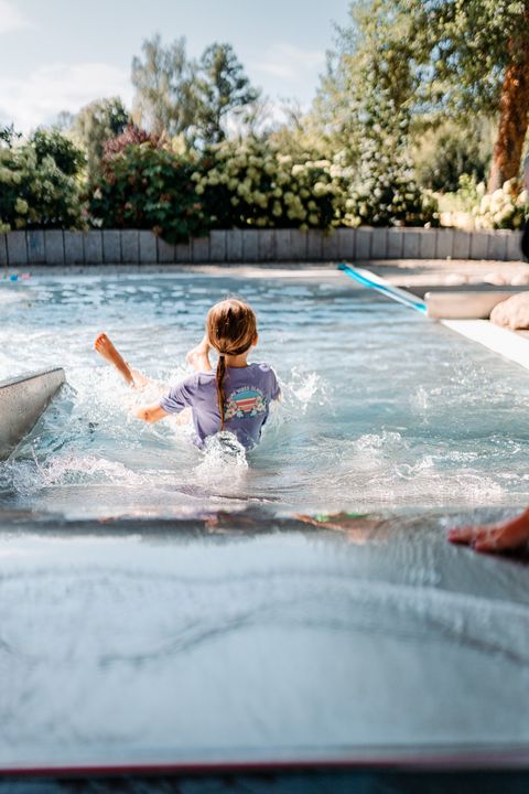 Mädchen rutscht im Kleinkindbecken