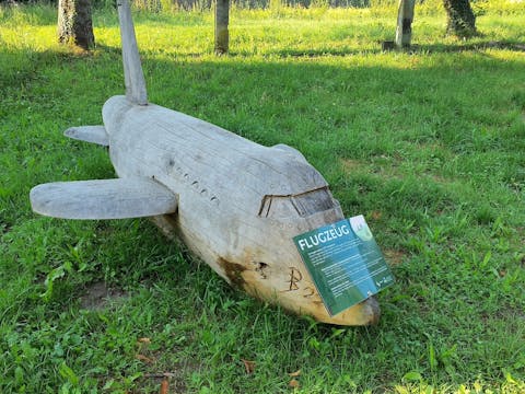 Eine der Holzskulpturen stellt ein Flugzeug dar
